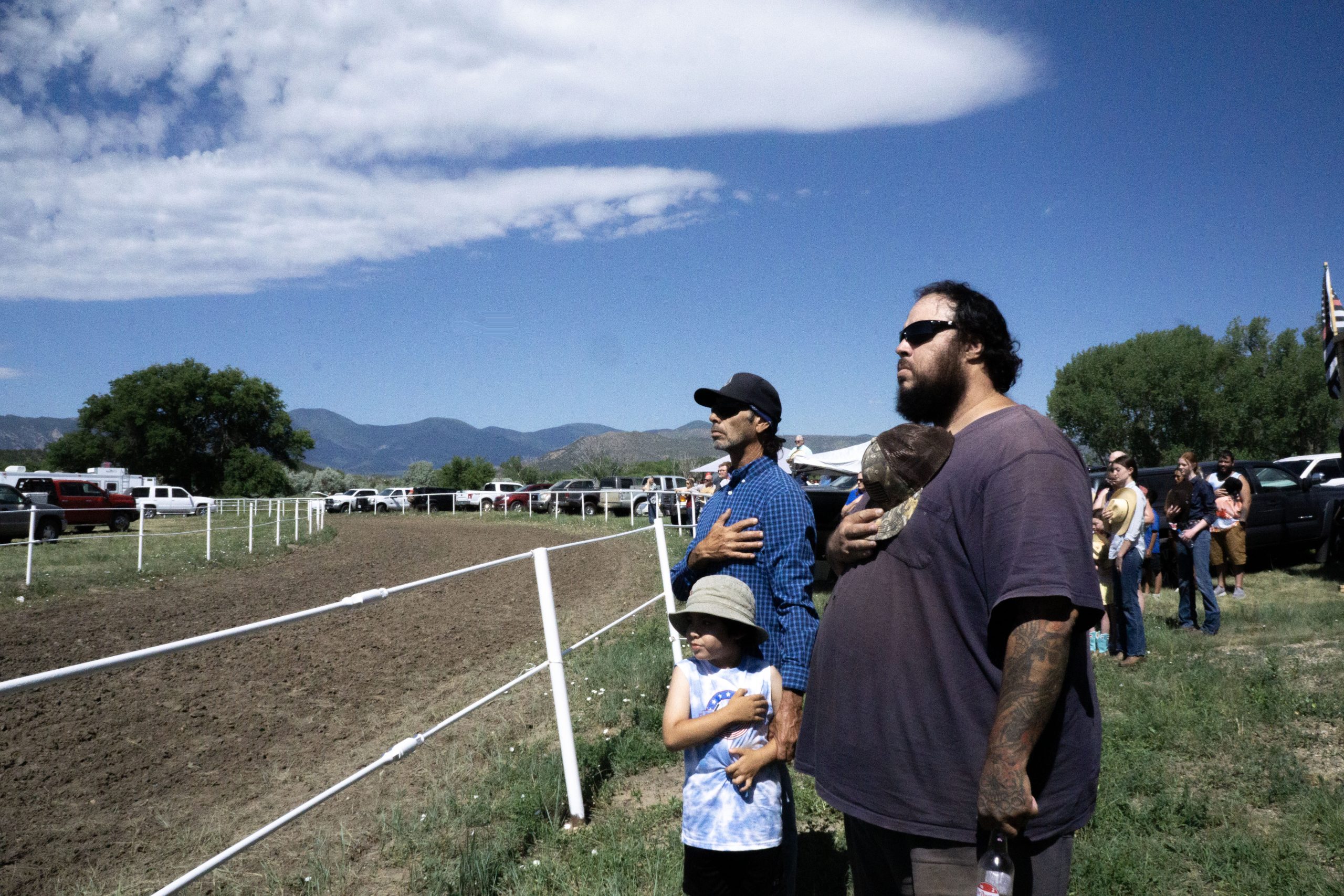 Viewers of the rodeo sing the national anthem
